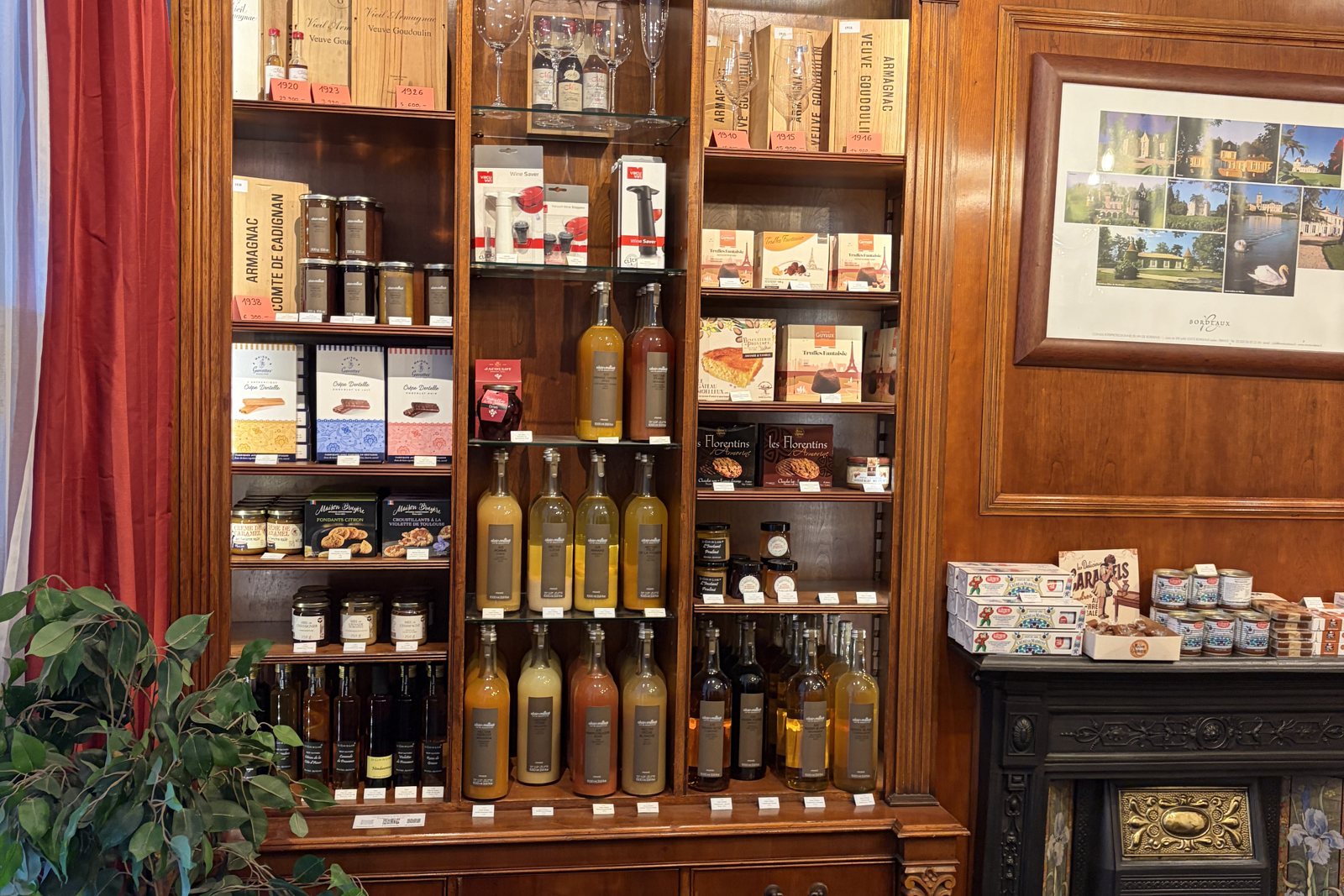 Vintage Armagnac in wooden boxes and delicatessen on the shelf at Laroche