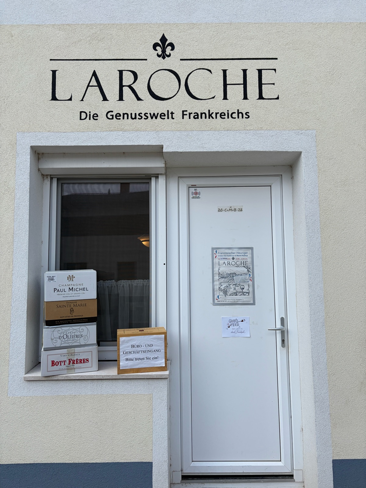 The entrance to Laroche: a white door with the Laroche lettering above it and notices in the window