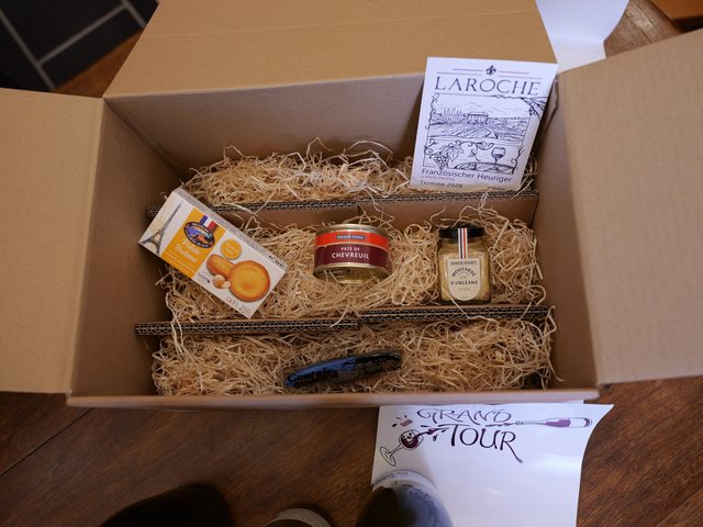 Offene Grand-Tour-Box mit der Feinkost im Stroh