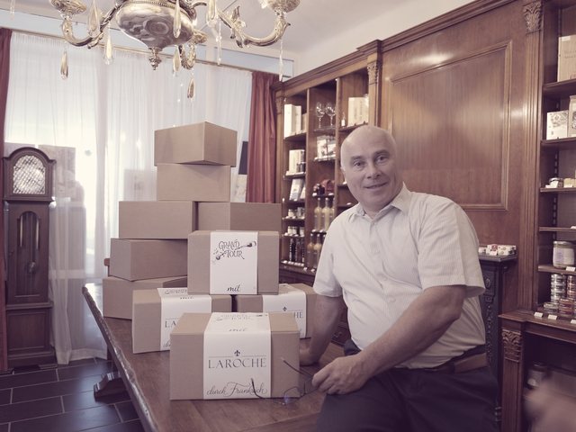 Louis-Pierre Laroche in seinem Geschäft in Markt Piesting, die Hände auf einer Grand-Tour-Schachtel