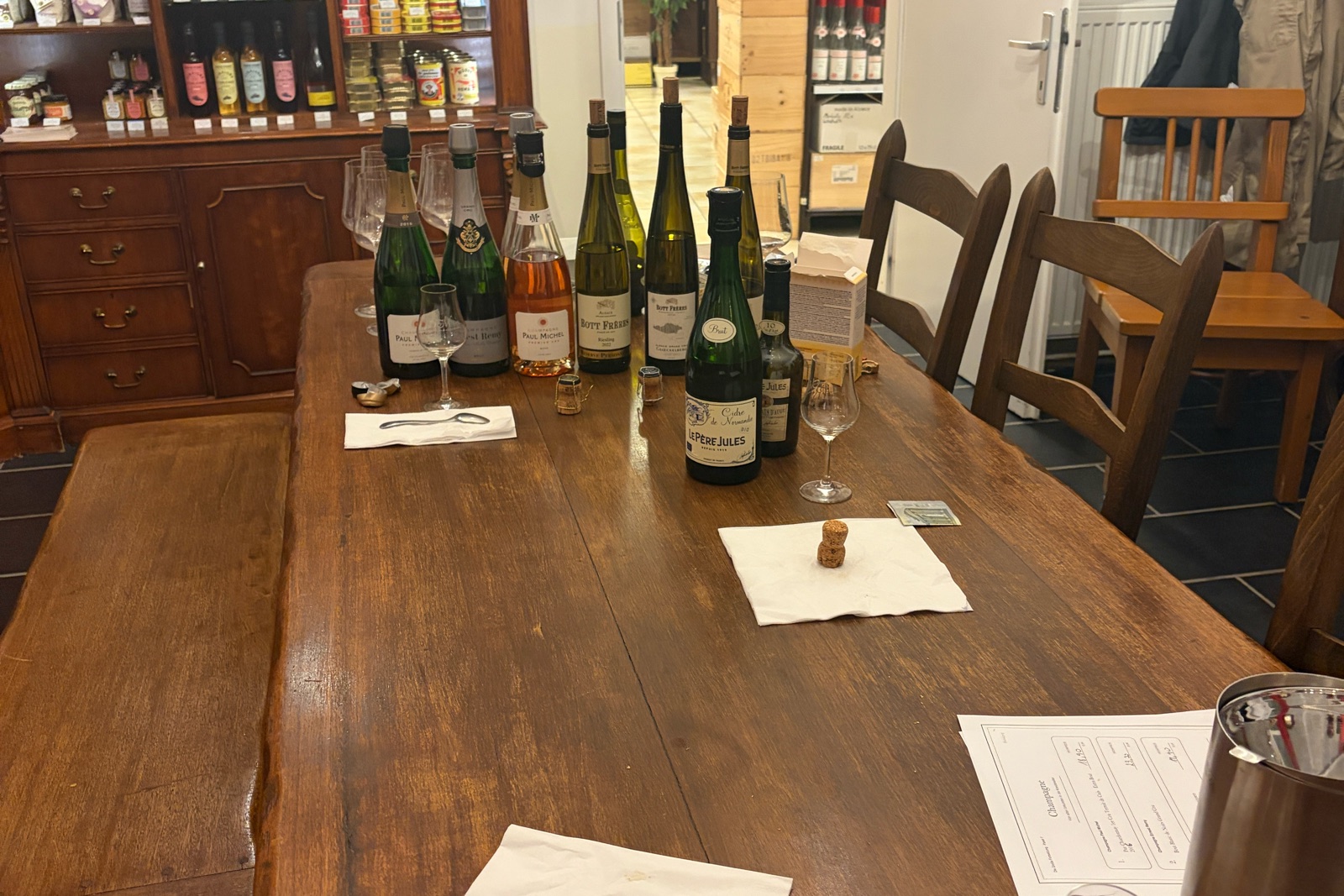 The wooden table in the store after the tasting: opened bottles, glasses and written sheets